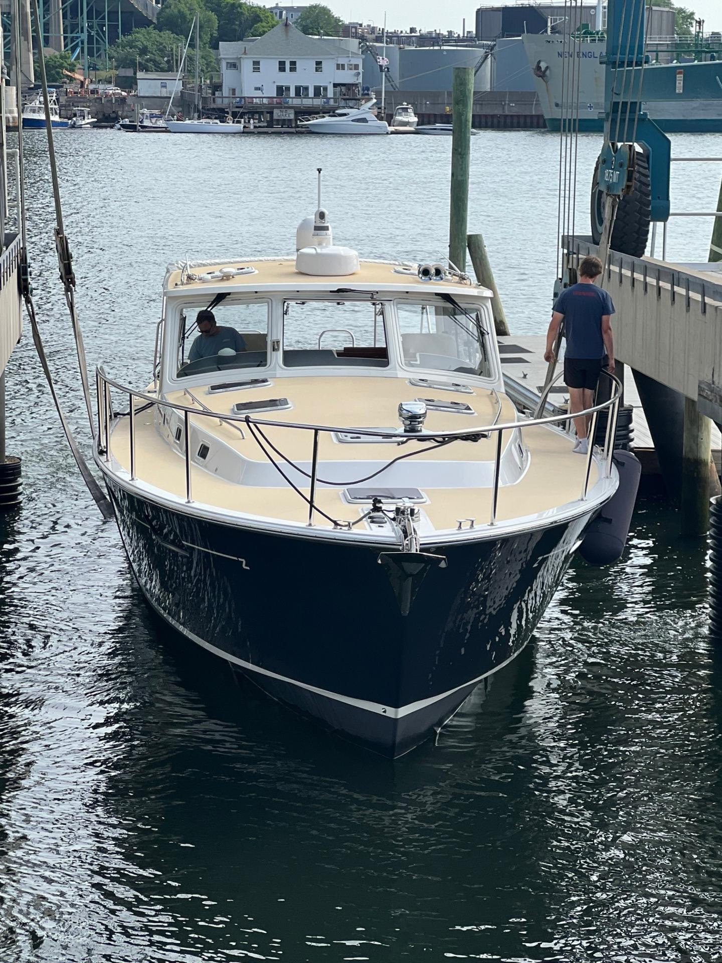 Boat docked at a marina with a man on the pier.