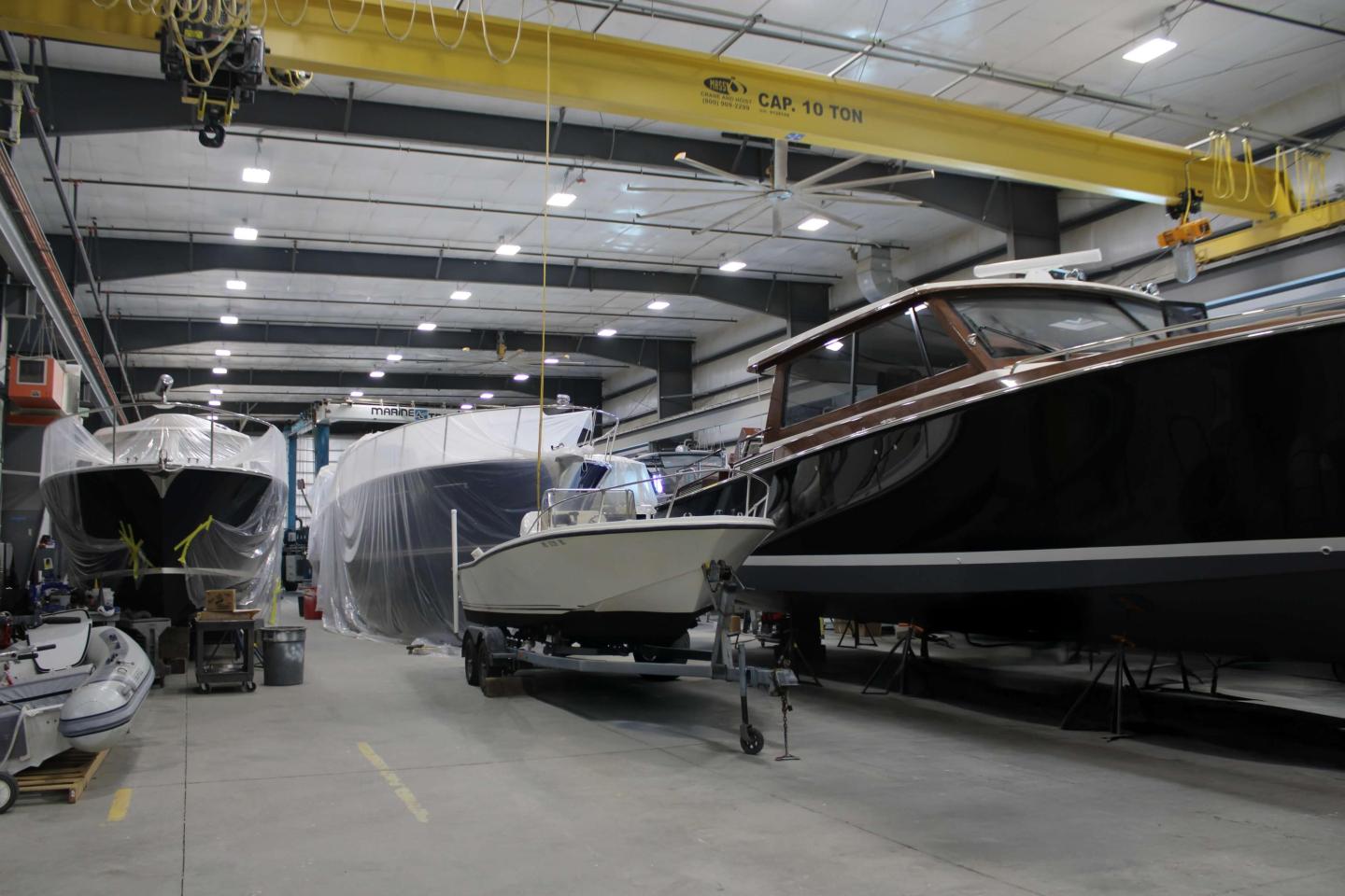 Boats under construction in a spacious indoor workshop.