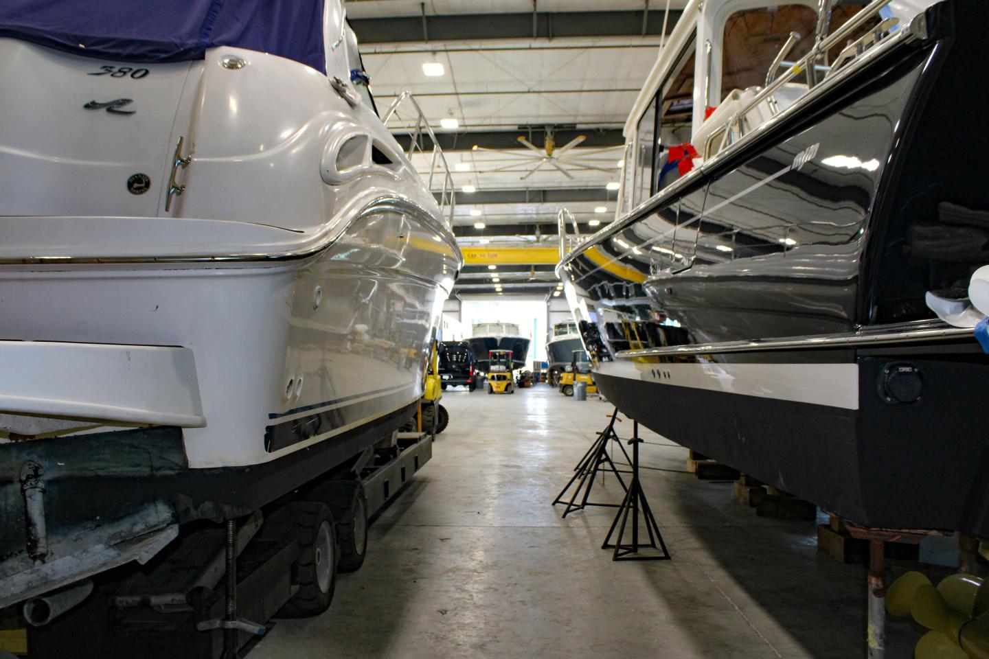 Boats on trailers inside a large warehouse.