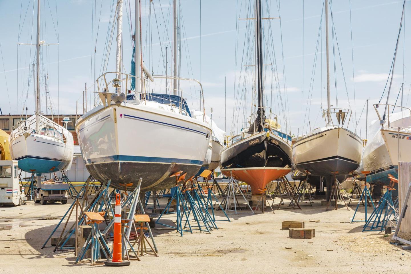 Boats on stands in a sunny boatyard.