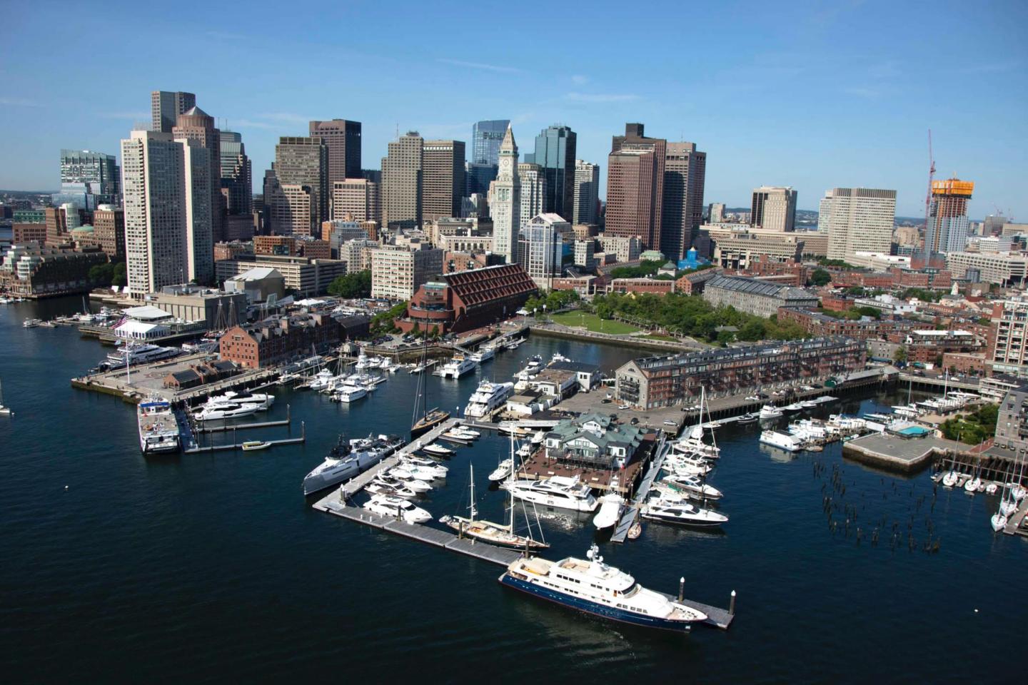 Aerial view of a city skyline with a busy marina in the foreground.