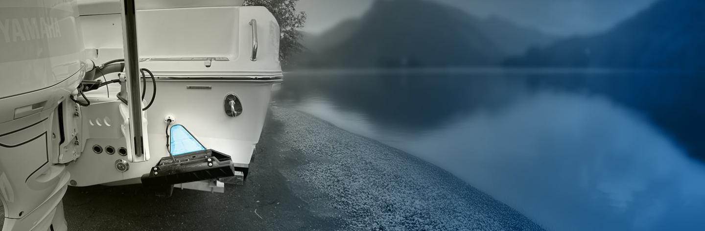 Boat docked by a serene lake with misty mountains in the background.